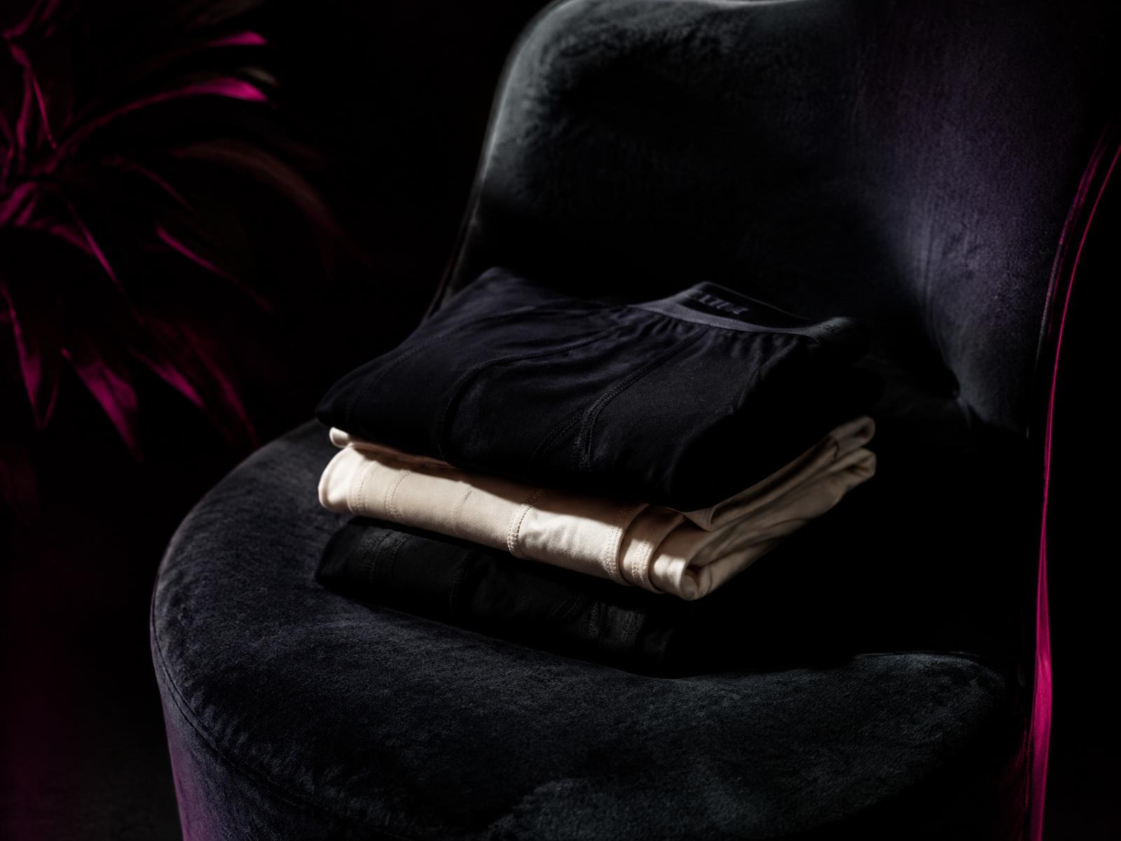 Folded SMUG underwear on a velvet chair
